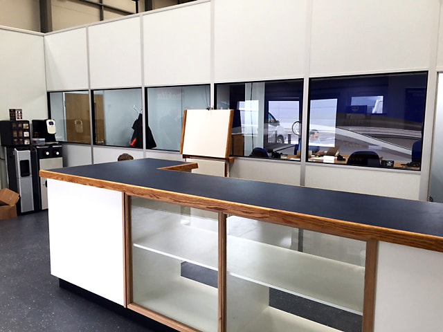 Bespoke Reception Desk with Front Glass Panels and Custom Shelving Units